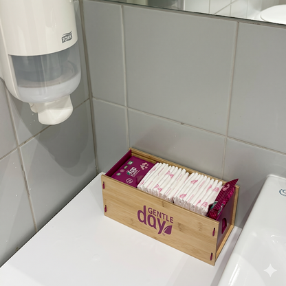 Bambuko dėžutė su „Gentle Day“ higienos priemonėmis (paketais, tamponais ir servetėlėmis) pastatyta WC kambaryje šalia kriauklės